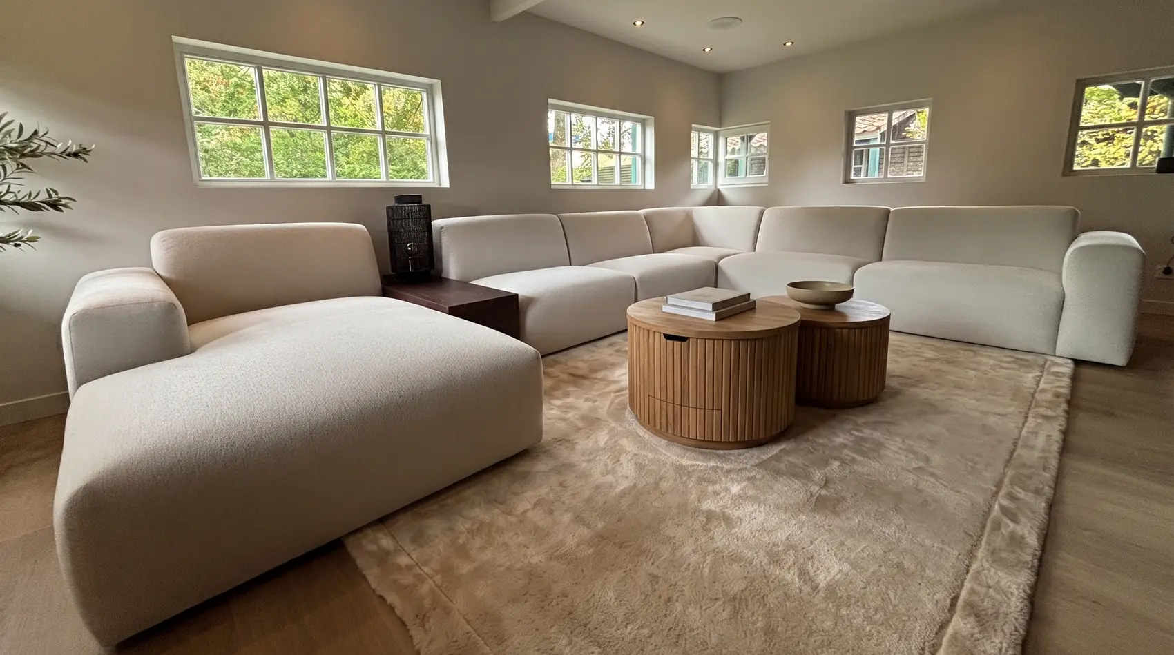 Modulaire hoekbank Vendi met ronde teakhouten salontafel Bailar en vloerkleed Sophisticate van Rivièra Maison