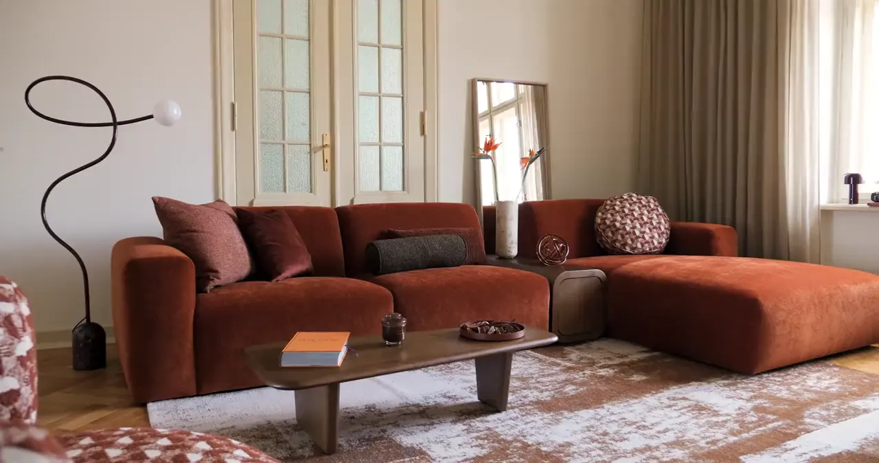 Hoekbank Vendi in warme roestkleur in een lichte woonkamer
