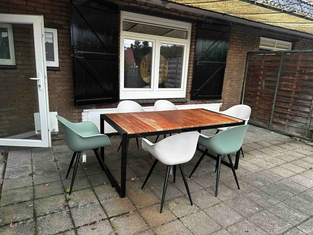 Zonnig prive dakterras bij het appartement van Mokana met houten tuintafel en 6 stoelen