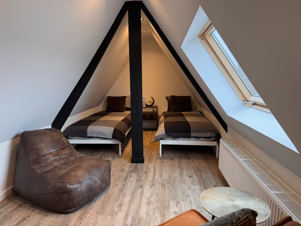 Slaapkamer 4 op de bovenste etage met twee eenpersoons boxsprings en leren zitzak