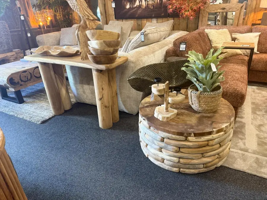 Teakhouten sidetable en ronde boomstam salontafel bij een beige en roestbruine bank